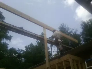 Carpenter setting a ridge beam over a new addition frame — Ice Dam Removal by Roofing Brothers in East Stone Gap