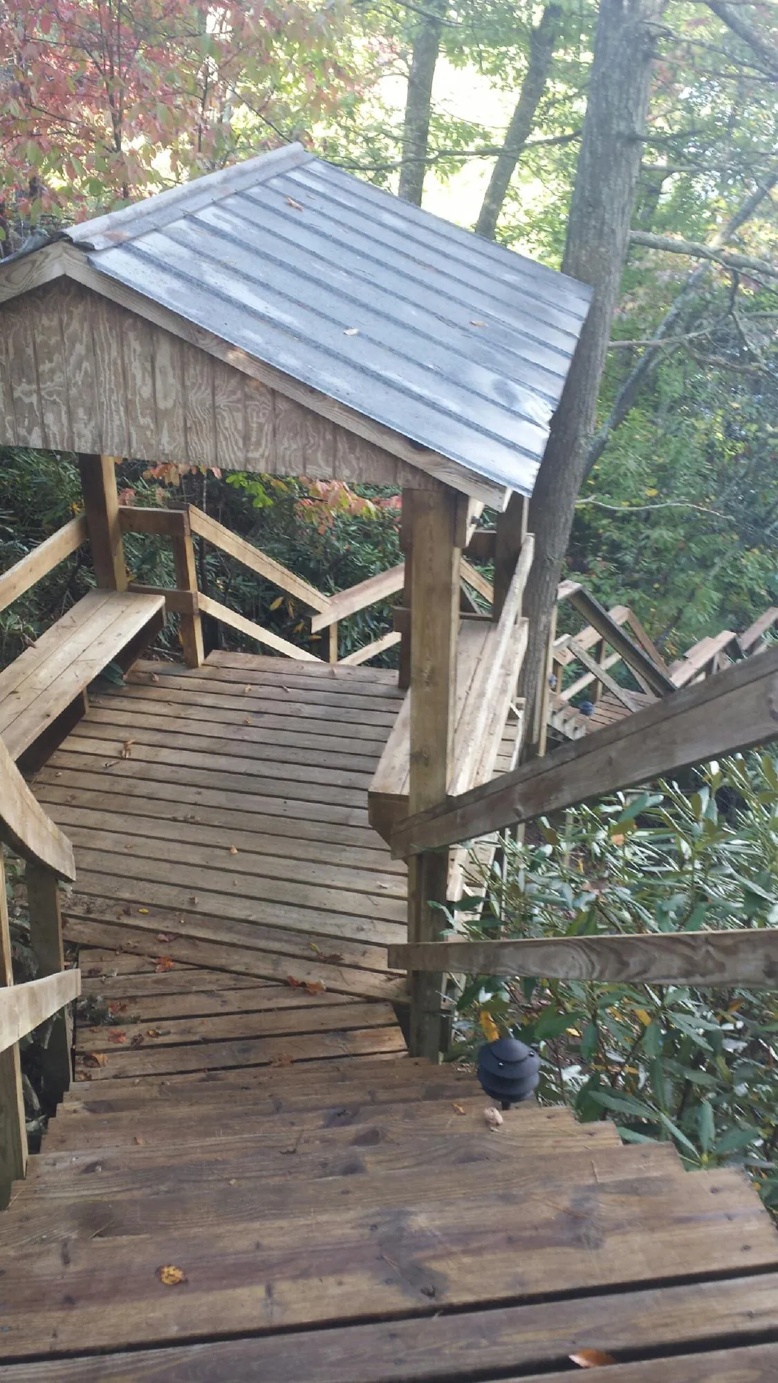Metal roofed shelter over wooden steps on a wooded walkway — Skylight Repair & Installation work by our crew in East Stone Gap