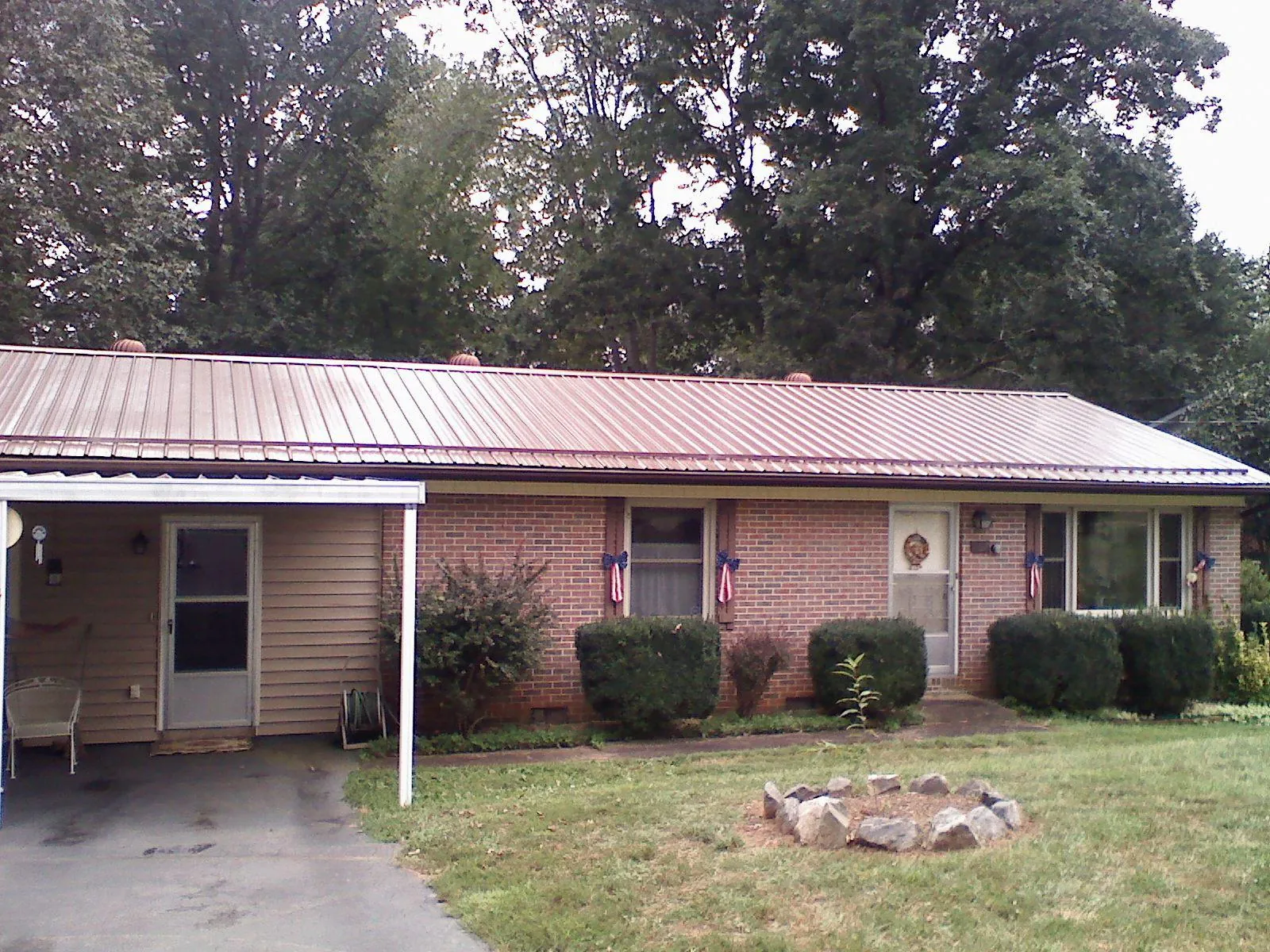 Bronze metal roof and carport on a brick ranch home — Roof Repair work by our crew in East Stone Gap